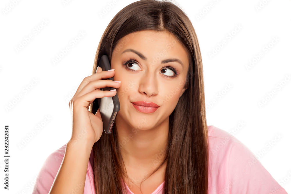 dissatisfied young woman talk in her smartphone on white background dissatisfied young woman talk in her smartphone on white background