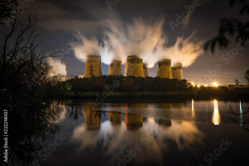 The Cooling Towers Of Drax Power Station Viewed Over A Lake At Night