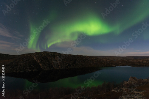Northern lights, aurora in autumn over the lake. © Moroshka