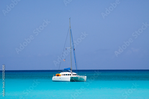 Fotomurale White catamaran anchored near the sunny coast of Half Moon Beach, Bahama´s
