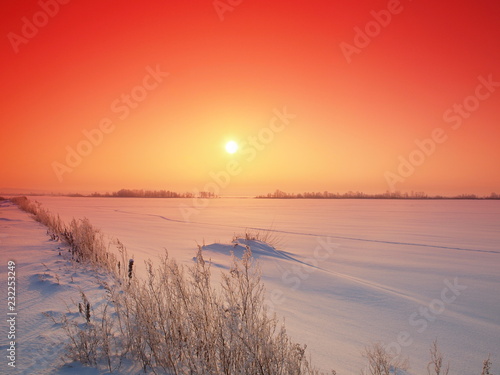 Fototapeta Naklejka Na Ścianę i Meble -  Sunset and snow-covered grass. Winter, Russia, Ural, Perm Region
