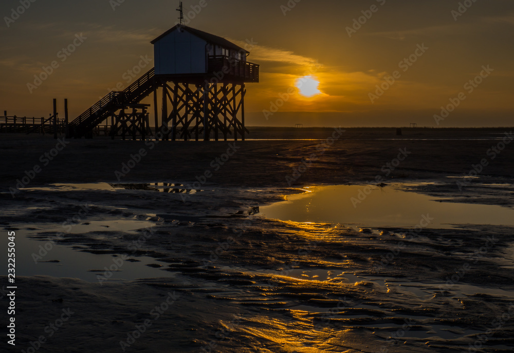 Pfahlbau an der Nordsee im Sonnenuntergang Pfahlbau an der Nordsee im Sonnenuntergang