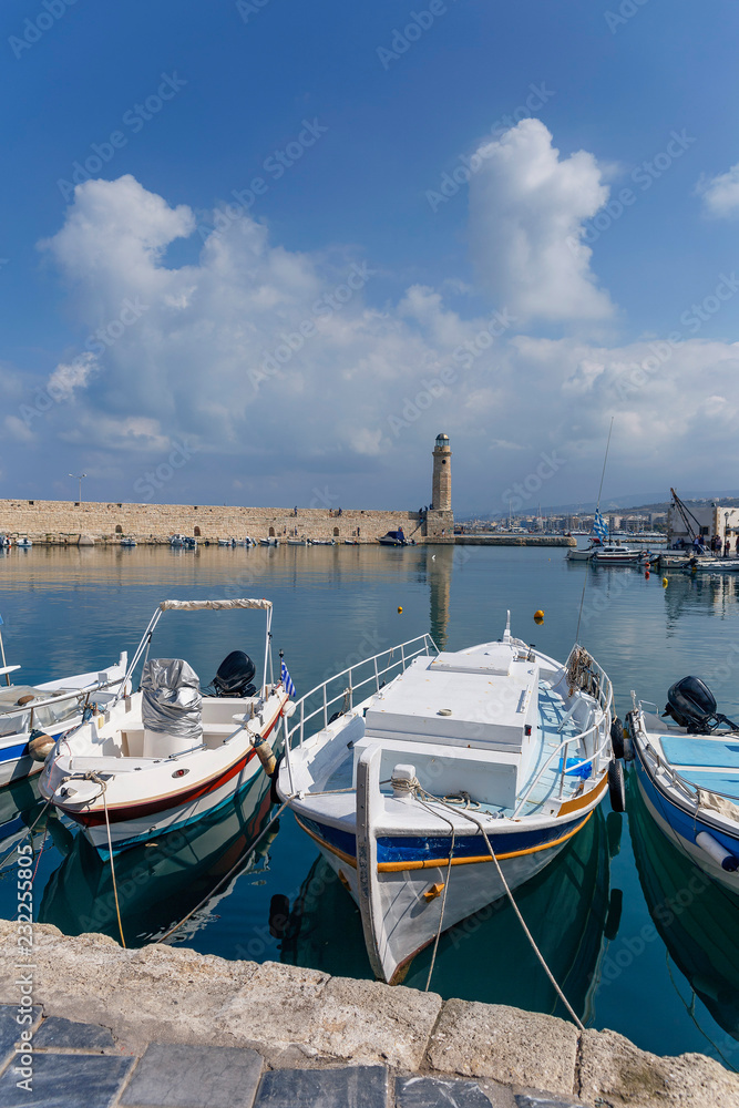 Fototapeta premium small motor boats in the harbor on against a cloudy sky background