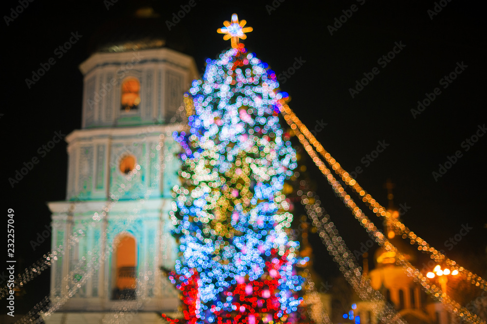 Blurred background. Christmas tree decorated with lights  at night.