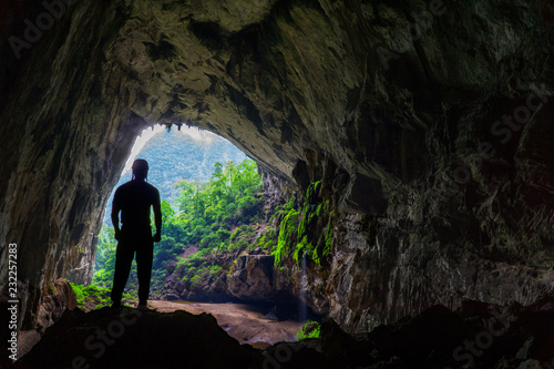 Hang En Cave - Silhouette of Man Standing Inside Large Cave. Victorious, explorer concept