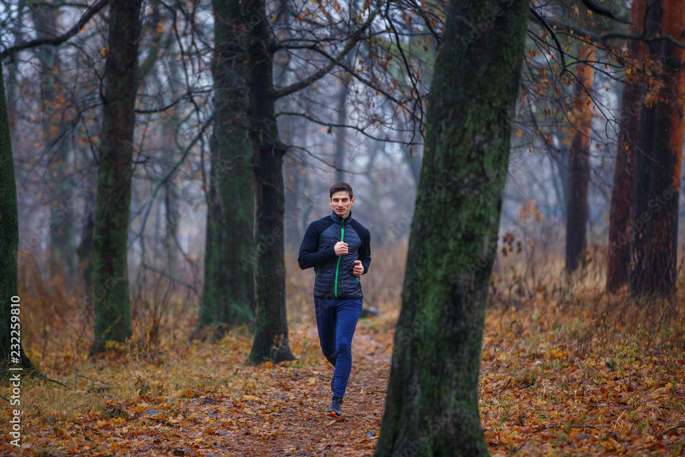 Young man jogging in autumn park in the morning Young man jogging in autumn park in the morning