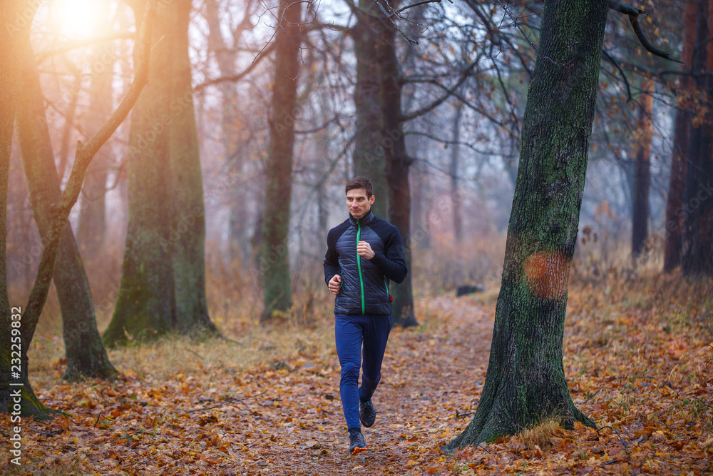 Young man jogging in autumn park in the morning Young man jogging in autumn park in the morning