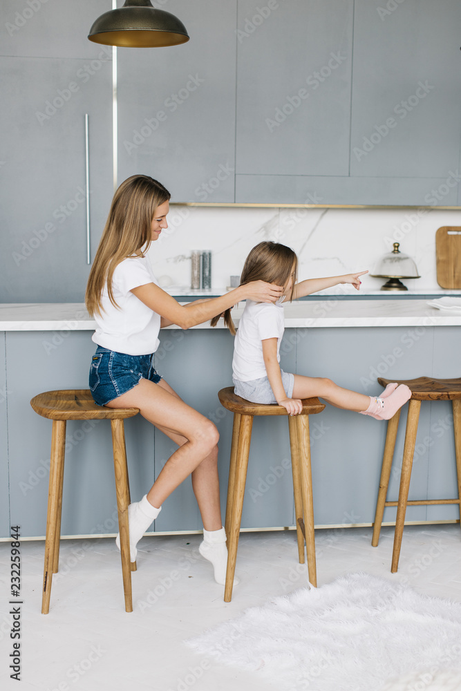 mother braids her daughter's hair mother braids her daughter's hair