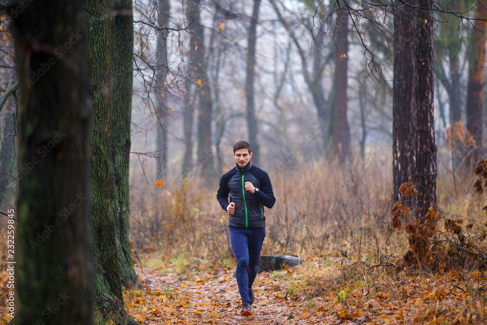 Young man jogging in autumn park in the morning Young man jogging in autumn park in the morning
