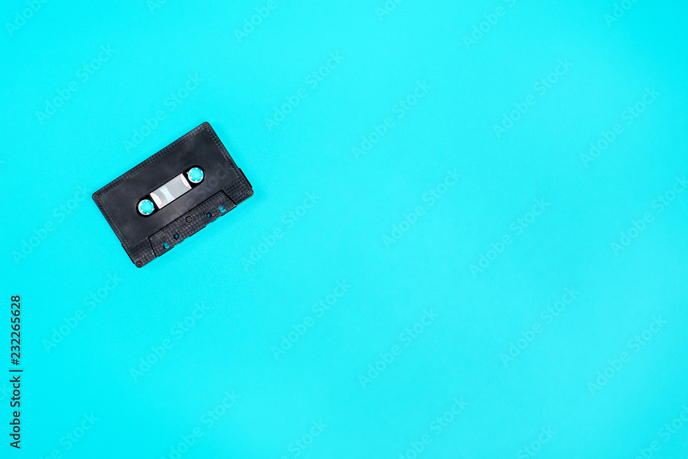Fototapeta premium Retro black plastic audio cassette laying on the green metal table