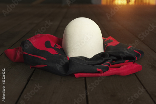 Fotografie albanian hat and albanian flag on wooden planks in front of fireplace