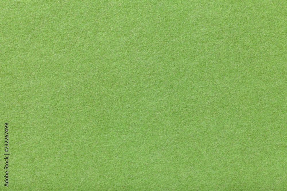 Fototapeta premium Light green matt suede fabric closeup. Velvet texture of felt.