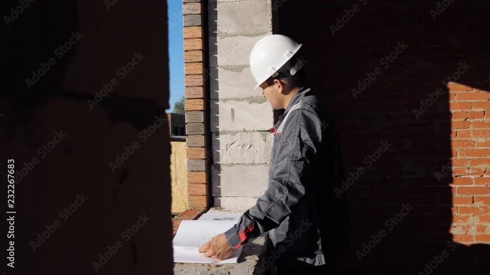 Man with paper draft in building under construction Man with paper draft in building under construction