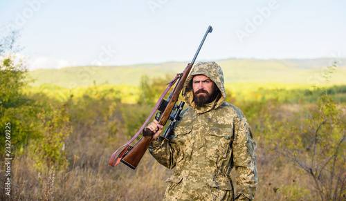 Hunting season. Guy hunting nature environment. Bearded hunter rifle nature background. Hunting big game typically requires tag each animal harvested. Experience and practice lends success hunting