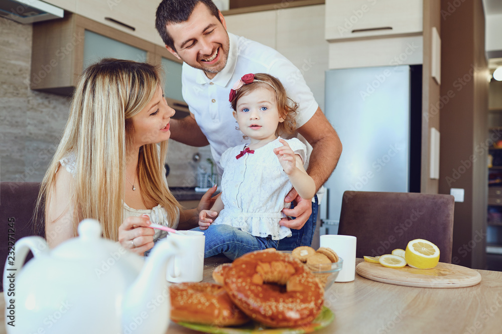 A happy family in the kitchen while sitting at a table. A happy family in the kitchen while sitting at a table.