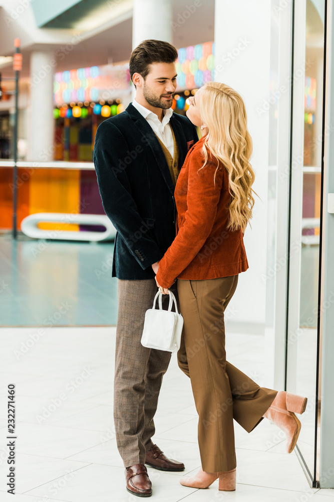 young couple hugging and spending time in shopping center