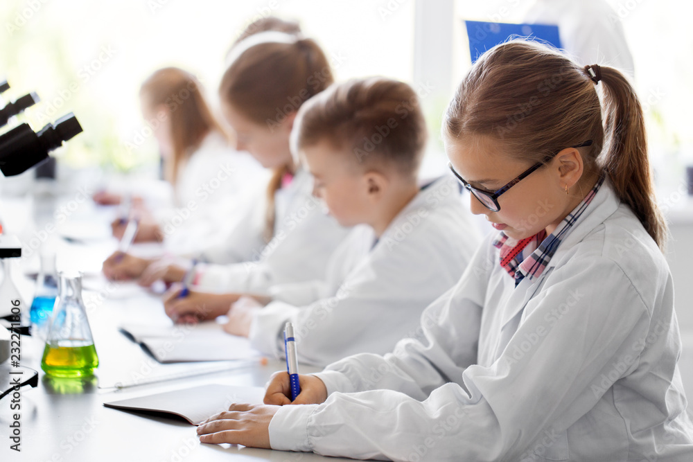 education, science and children concept - teacher and kids studying chemistry at school laboratory and writing to workbooks education, science and children concept - teacher and kids studying chemistry at school laboratory and writing to workbooks