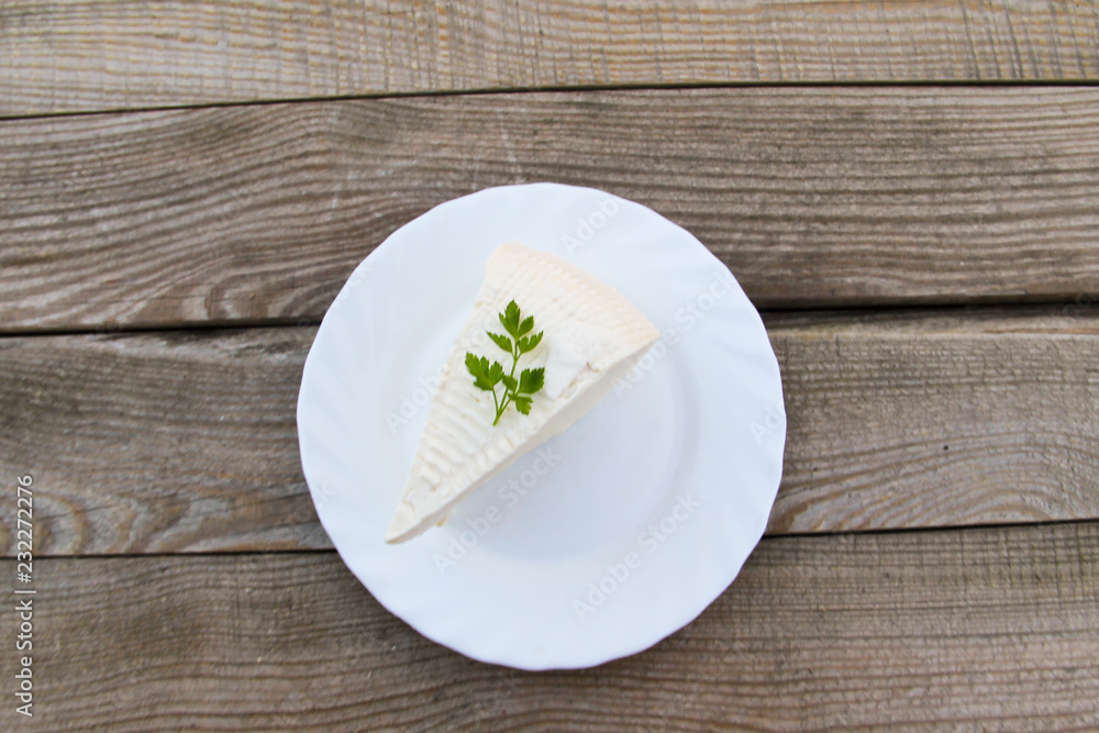 Bryndza in a plate on wooden table. Top view Bryndza in a plate on wooden table. Top view