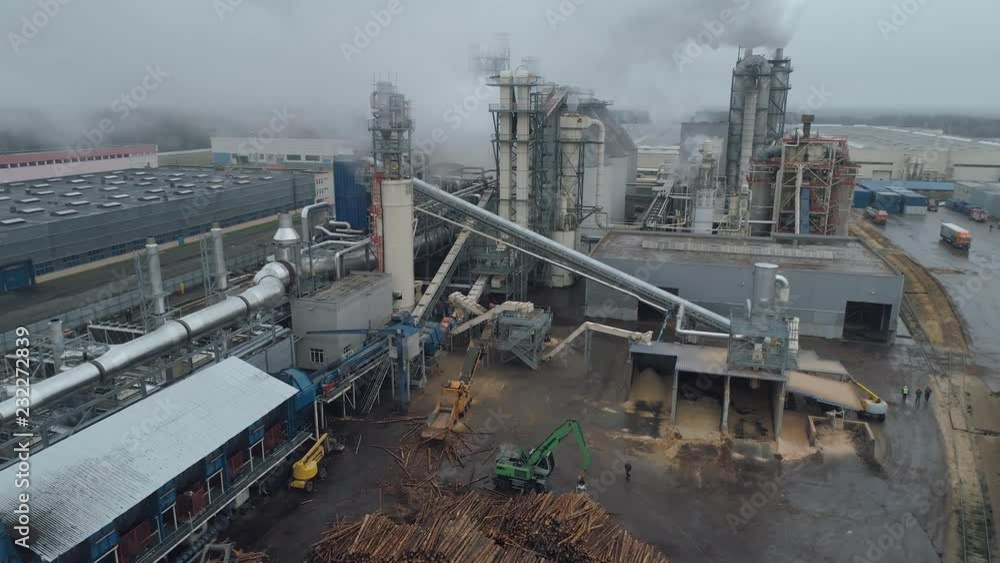 Woodworking factory aerial view of pipes and tanks, industrial landscape, smoke from pipes. Woodworking factory aerial view of pipes and tanks, industrial landscape, smoke from pipes.