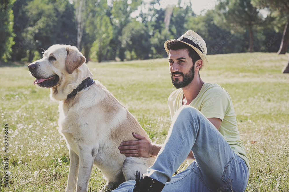 Canadian labrador dog resting in the park with his owner on a sunny day Canadian labrador dog resting in the park with his owner on a sunny day