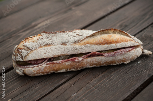 closeup of traditional french sandwich with pork sausage on wooden table