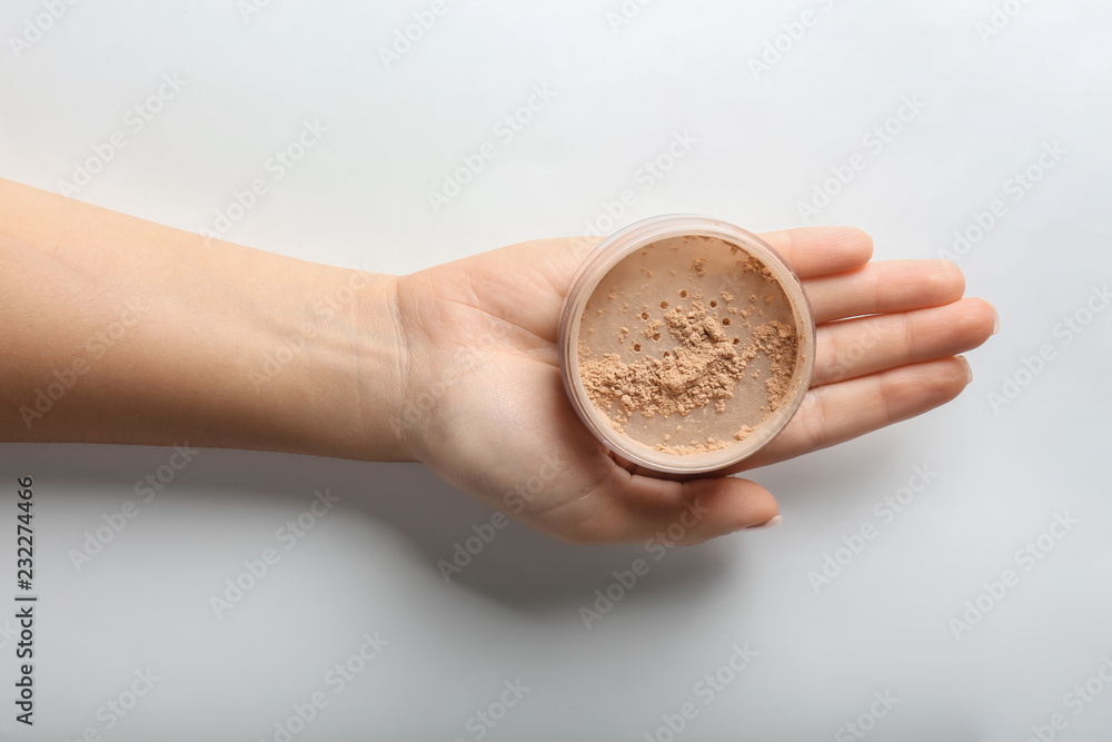 Fototapeta premium Woman holding powder on white background