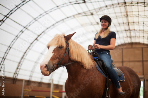 Young adult beautiful woman in helmet learning Horseback Riding © olsima