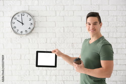 Young man holding tablet co...