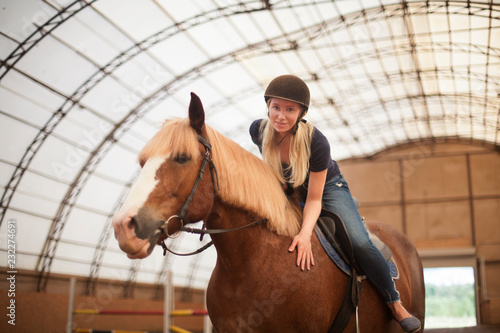 Young adult beautiful woman in helmet learning Horseback Riding © olsima
