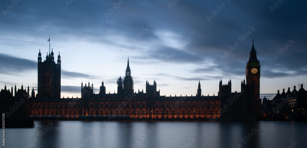 London, UK - Intentionally under-exposed panoramic view of The Houses of Parliament and the Big Ben silhouetted against sky at dusk. Long exposure shot.