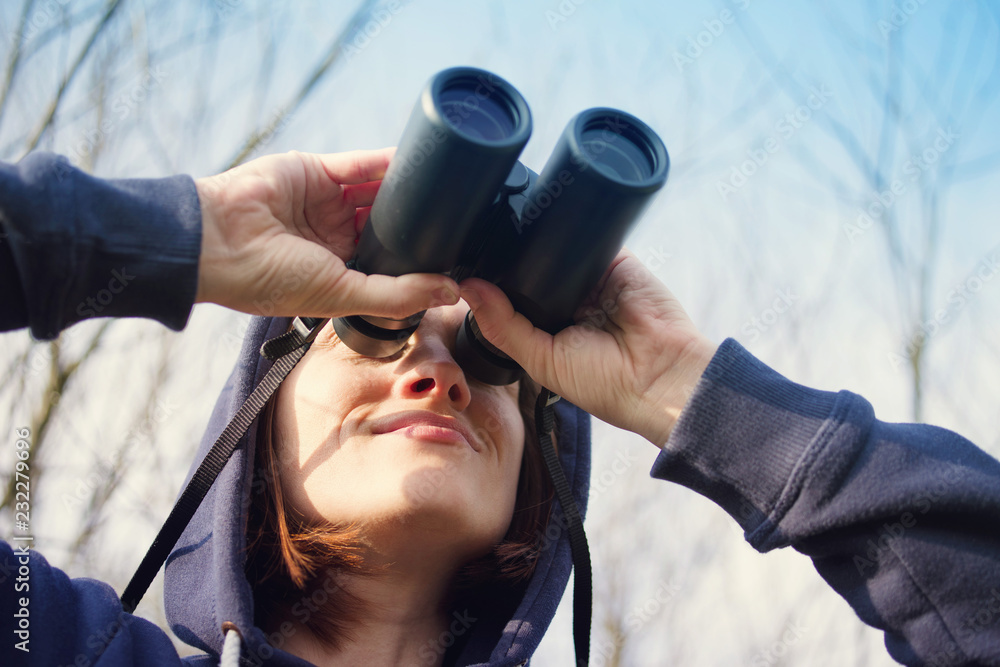 Girl with the field-glass watches birds. Ornithology. Birdwatching - obrazy, fototapety, plakaty 