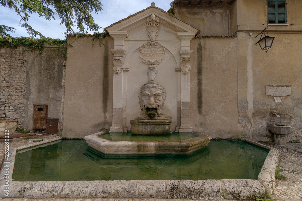 Old fountain (Fontana del Mascherone) on the wall of the thirteenth-century former church of Saints Simon and Jude in Spoleto, Umbria, Italy Old fountain (Fontana del Mascherone) on the wall of the thirteenth-century former church of Saints Simon and Jude in Spoleto, Umbria, Italy