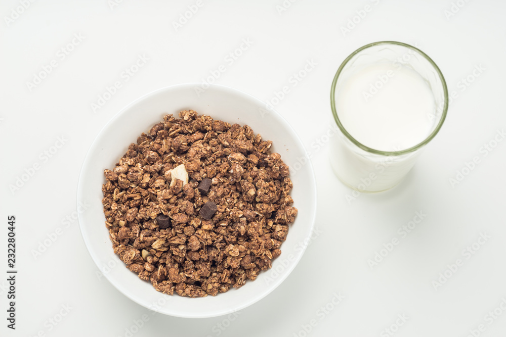 Fesh milk in the glass and muesli breakfast placed on white background Fesh milk in the glass and muesli breakfast placed on white background