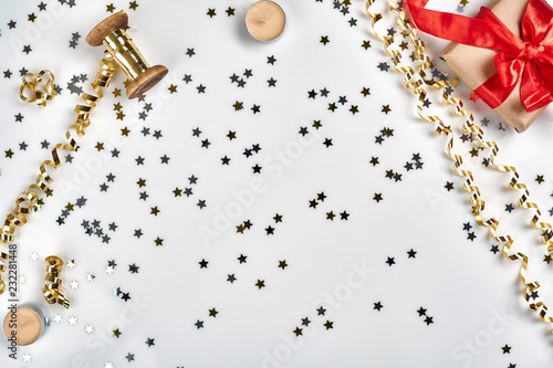 Delicate wavy ribbons and metallic star shaped confetti isolated on white background. Christmas holidays decoration concept.