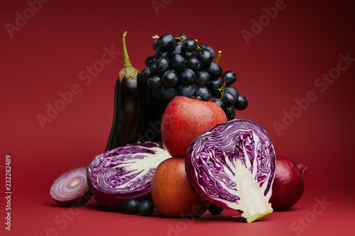 Valokuva close-up view of apples, grapes, eggplant, cabbage and onions on red