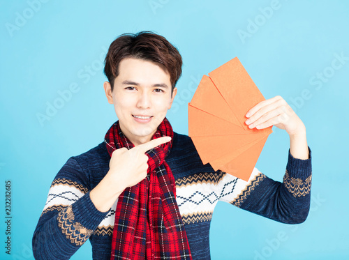 smiling asian man showing the red envelope