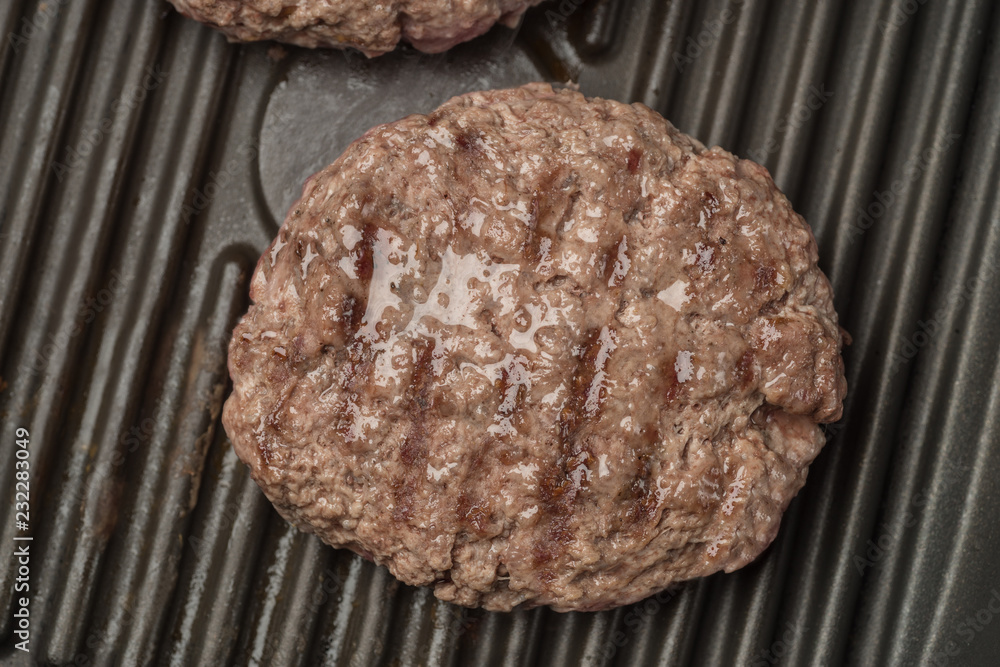 Food: fried homemade burger on a frying pan. Food: fried homemade burger on a frying pan.