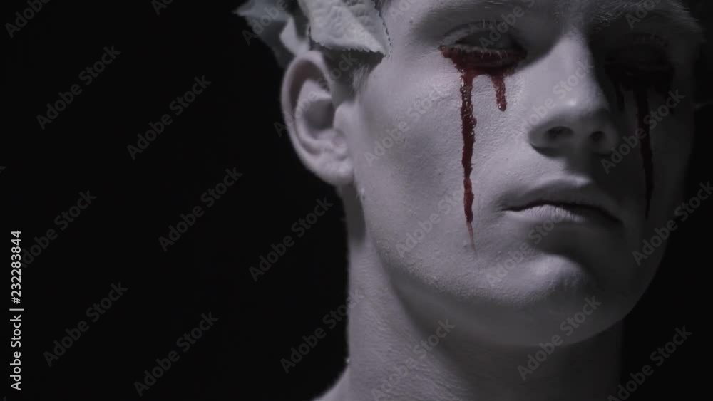 Living statue with bloody tears on his face, looks up Living statue with bloody tears on his face, looks up