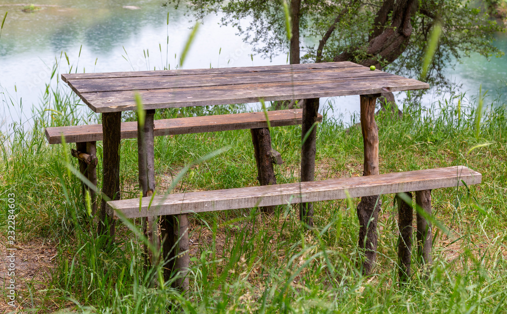 Wooden bench with a table by the lake Wooden bench with a table by the lake