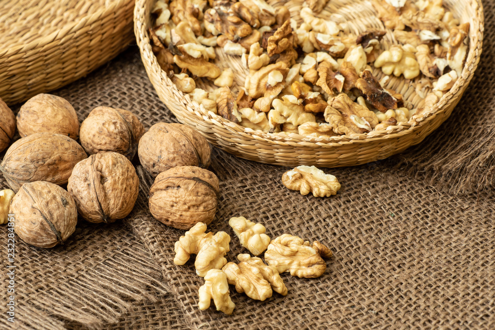 Walnuts on rustic natural burlap, Walnut kernels in wicker basket, Walnut background Walnuts on rustic natural burlap, Walnut kernels in wicker basket, Walnut background