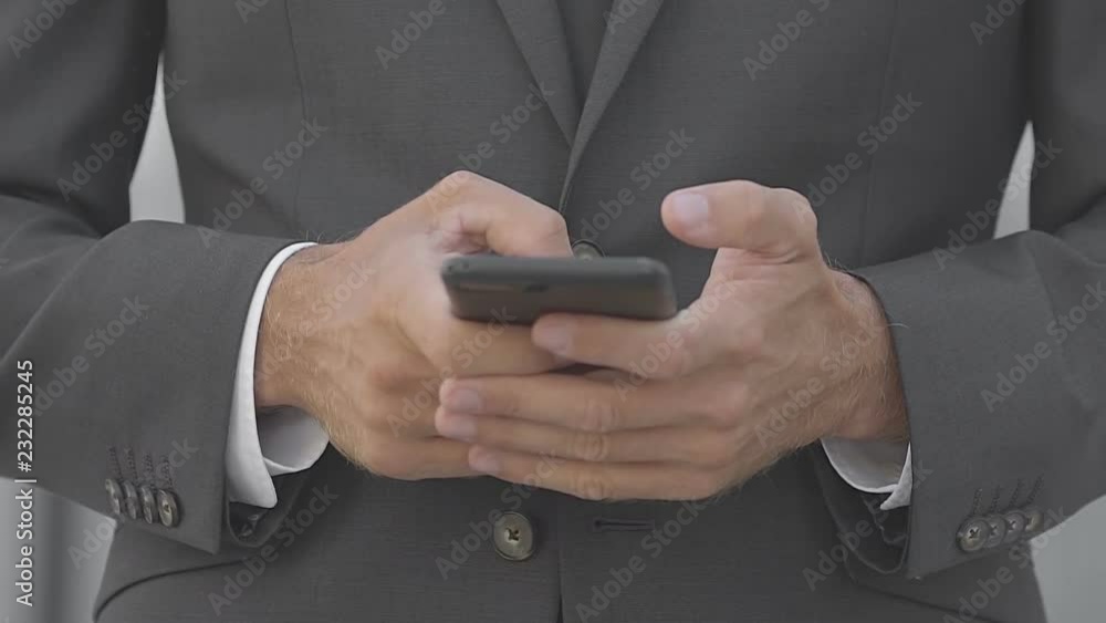 Cropped view of businessman chatting on street. Front view of manager in suit using smartphone. Communication concept Cropped view of businessman chatting on street. Front view of manager in suit using smartphone. Communication concept