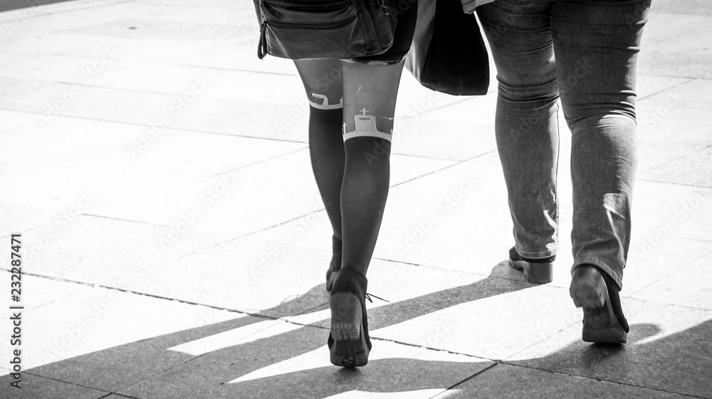 Obraz premium the leg of a young girl with sexy socks with church elements in black and white street photography. sexy pantyhose in urban environment