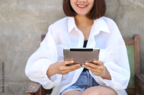 Soft focus of Woman hand holding tablet smart device with typing message or checking newsfeed on social networks, Communication technology concept