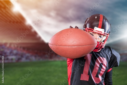 American football player with the ball isolated on a dark