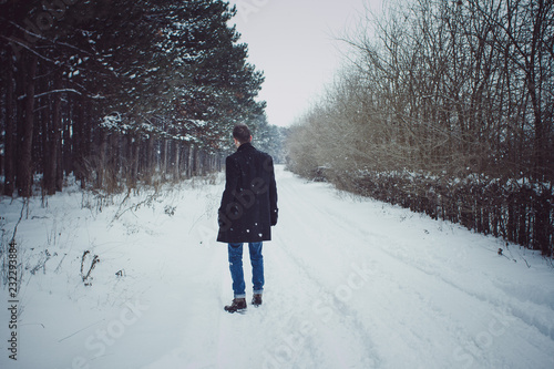 Portrait of young man walking in feald during snow storm photo