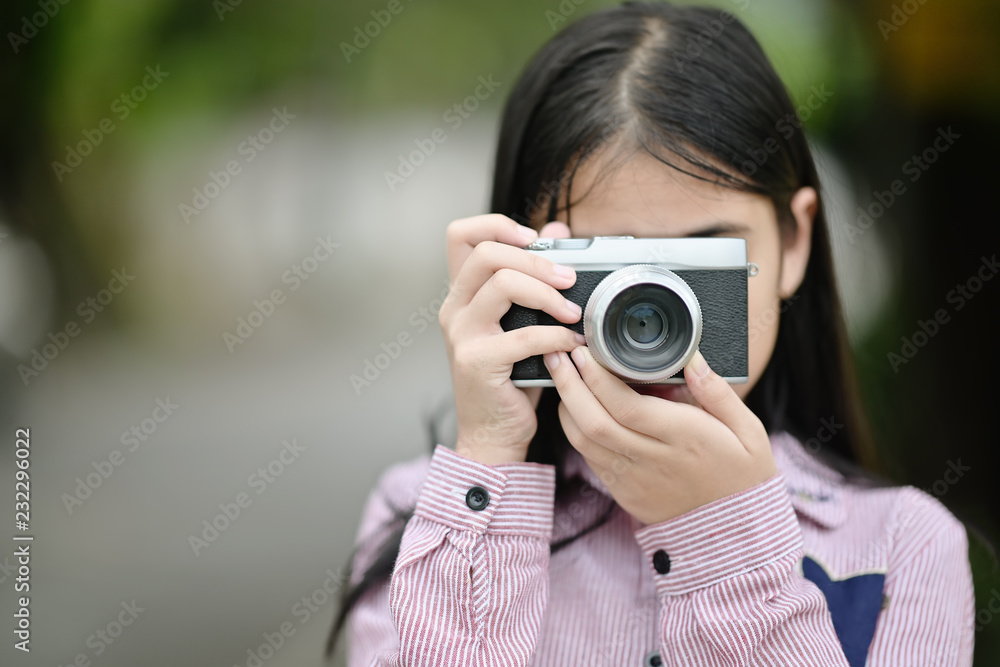 Girl taking pictures with a vintage camera.