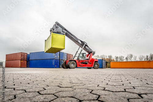 Fotografie Reach-Stacker carrying a yellow container