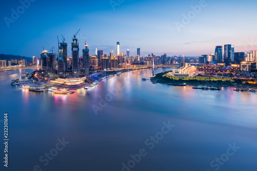 cityscape and skyline of downtown near water of chongqing at night