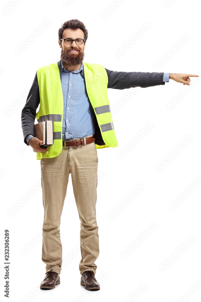 Young man holding books, wearing safety vest and pointing in one direction Young man holding books, wearing safety vest and pointing in one direction