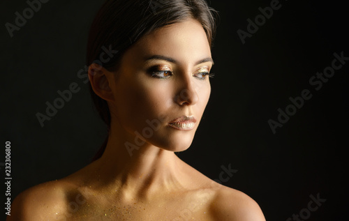 Close-up portrait of young woman with golden makeup. © Vladimir Arndt